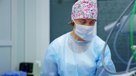 professional ophthalmologist discusses surgery operation with colleague. woman medic in scrubs and mask stands on modern equipment background.