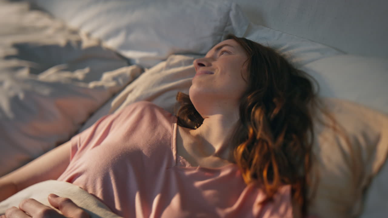 mañana mujer durmiendo a la luz del sol en primer plano. niña pacífica despertando en la cama.