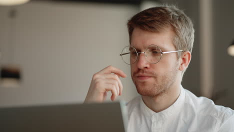 el trabajador de oficina está mirando la pantalla de la computadora portátil y pensando en leer información y enviar correo electrónico
