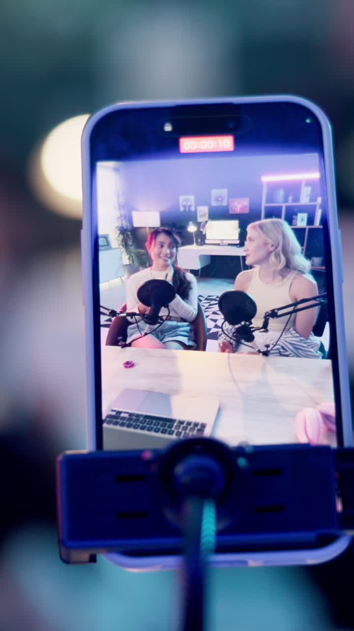 To kvinder, der optager en podcast på en smartphone