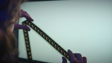 person examining filmstrip on a computer screen