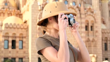 una turista se toma una foto contra el fondo de una mezquita, india