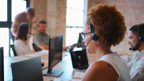 businesswoman in multi-cultural business team wearing headsets in customer support centre