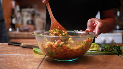 stirring a mixture of quinoa, chopped peppers and onions for a healthy vegan homemade recipe - slow motion