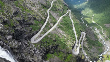 trollstigen mountain pass, norway - scenic route with waterfall and hairpin turns in romsdalen valley - pan right