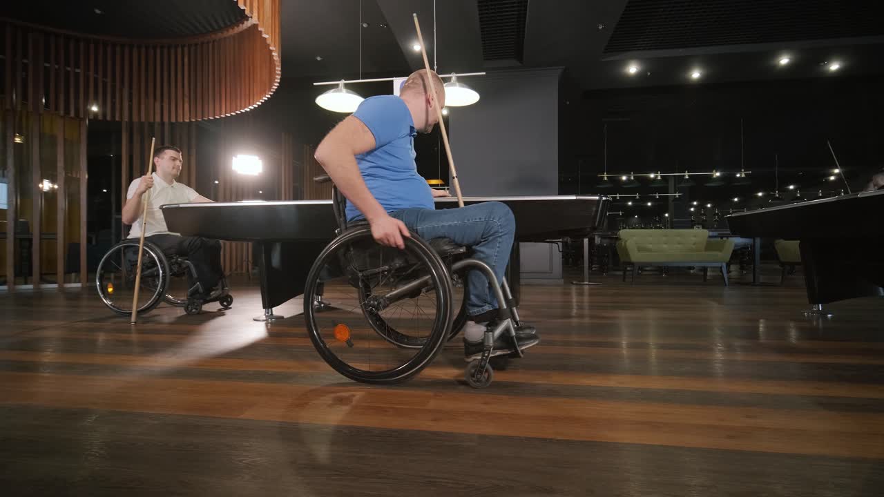 hombres adultos con discapacidad en silla de ruedas juegan al billar en el club