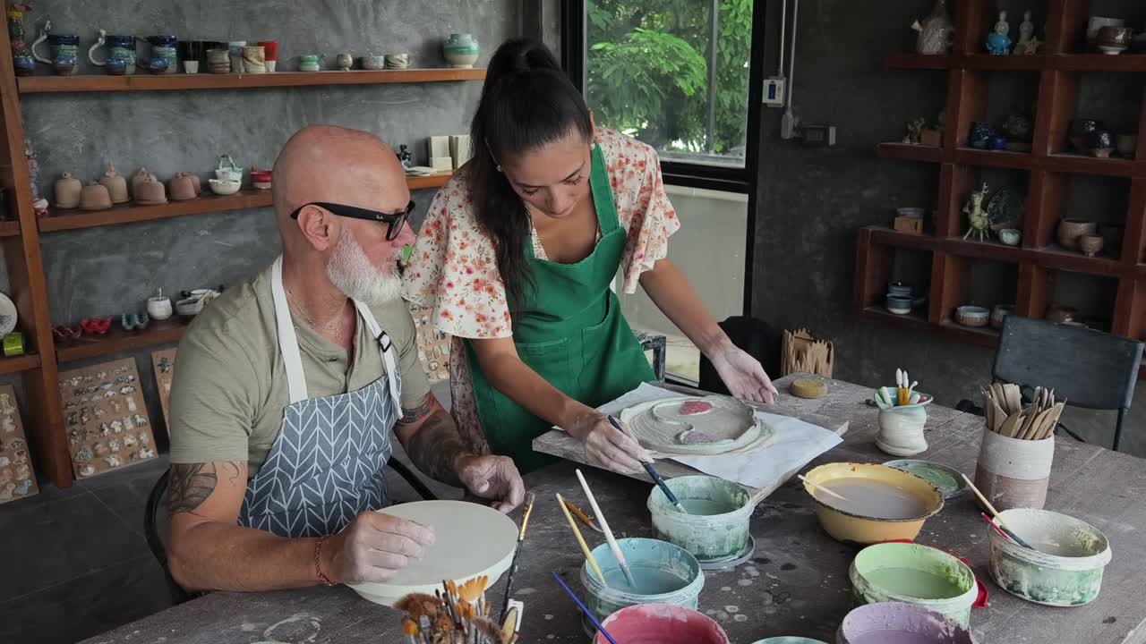 Coppia che decora ceramiche fatte a mano in un laboratorio creativo