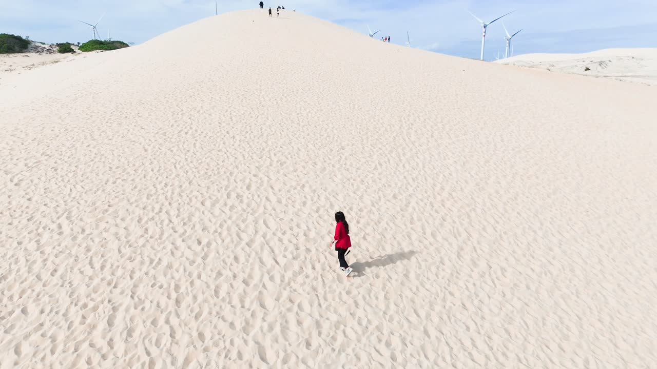 Aerial View of a Girl Walking on the Hill in the Desert.
