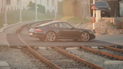 coche de lujo cruzando las vías del tren en europa