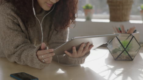 mujer joven cerca usando tableta viendo video sonriendo disfrutando de entretenimiento escuchando música usando auriculares