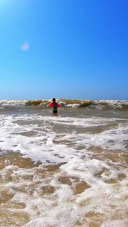 Boy having fun in sea. Excited child playing with sea waves