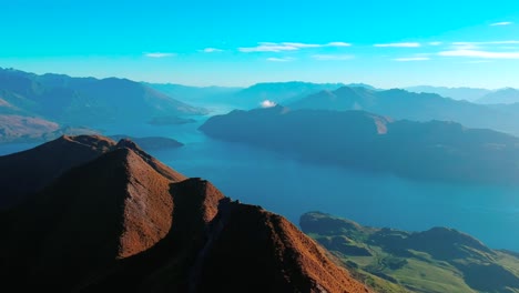 Drone-shot-of-Roy's-Peak-with-back-view-shot-of-a-man-at-the-tip