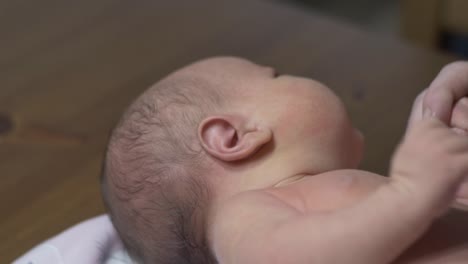 bebé recién nacido desnudo acostado y sosteniendo la mano de su madre