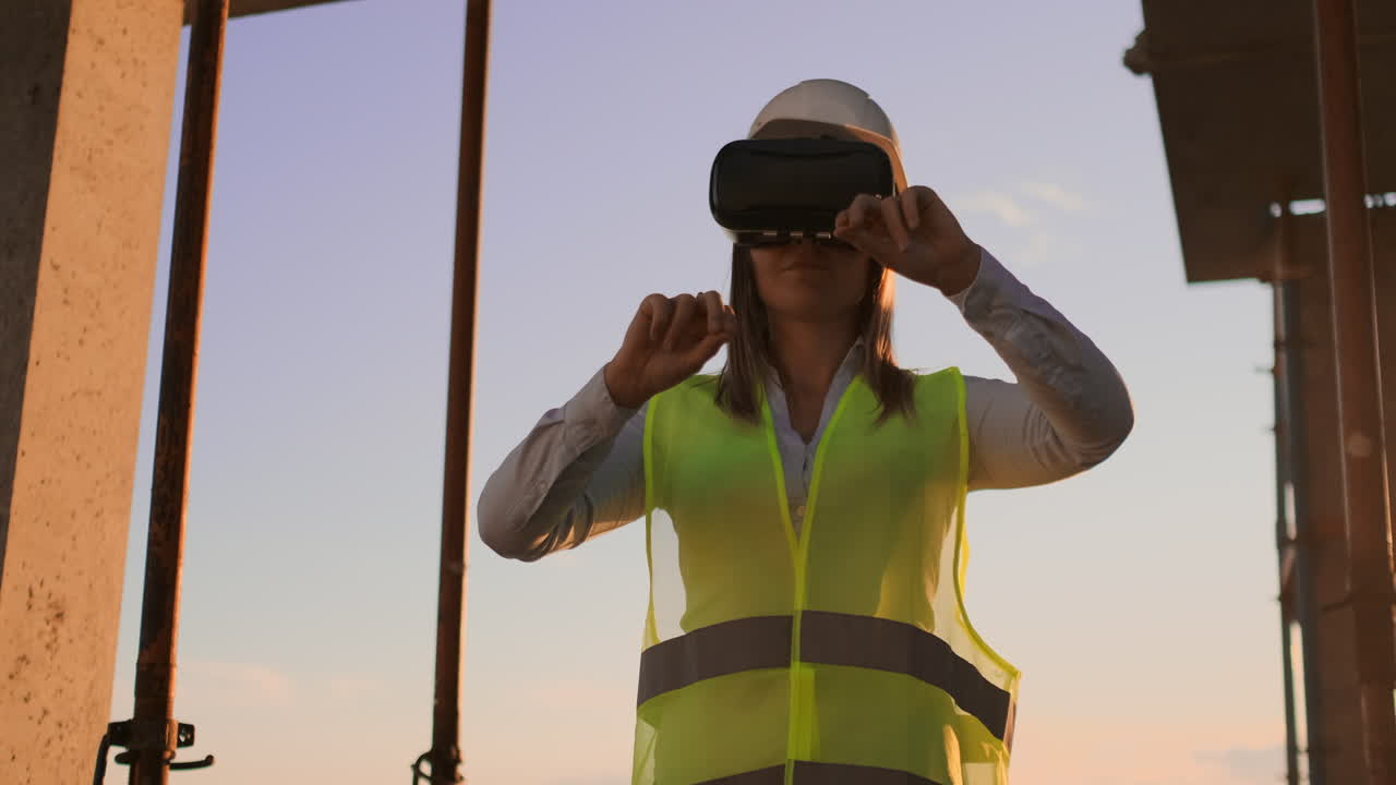 Female engineer in hardhat with VR glasses designing construction project at manufacturing plant