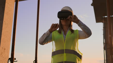 Female-engineer-in-hardhat-with-VR-glasses-designing-construction-project-at-manufacturing-plant