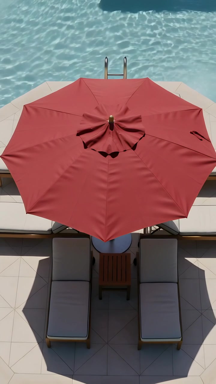 Video verticale: La telecamera panoramica dopo uno spostamento, mostrando un ombrellone rosso, sedie a bordo piscina e una scaletta.