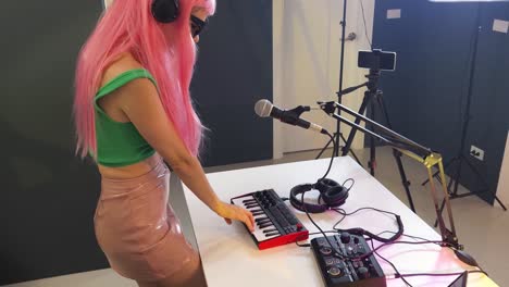 woman recording electronic music in studio