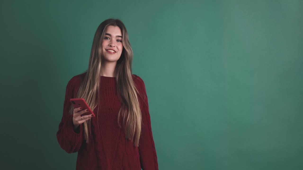 Woman holding a mobile while pointing aside