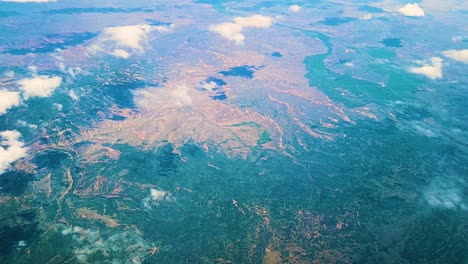 helicopter view of rocky mountain landscape and fluffy clouds in the atmosphere from helicopter flying in high altitude