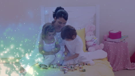 animation of glowing spots over happy biracial mother with son and daughter playing together