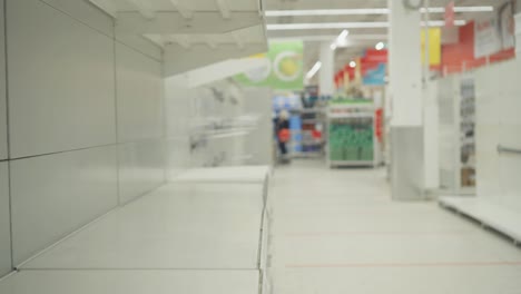un hombre con una máscara y guantes compra papel higiénico en pánico.