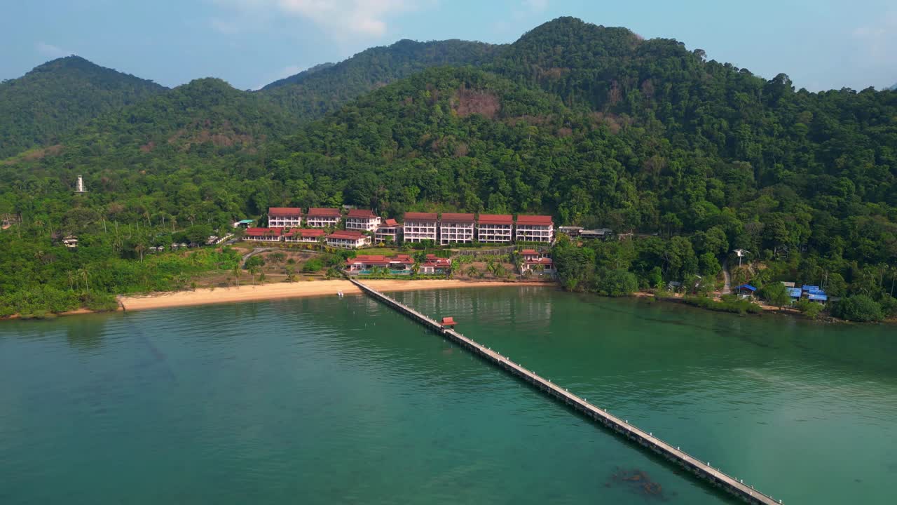 long pier reaching a beautiful resort by the sea in a tropical island koh chang. Beautiful aerial view flight ascending drone