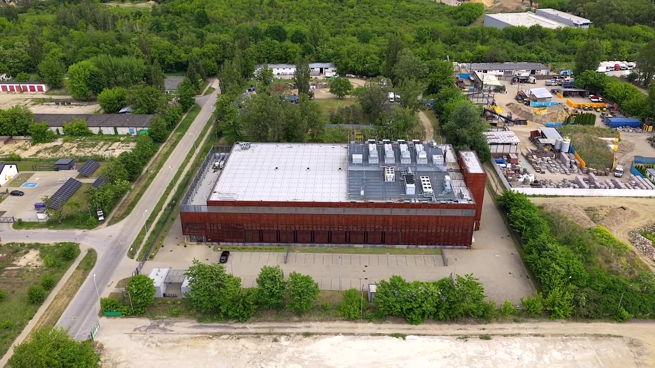 Imágenes de dron orbitando un gran y moderno edificio de centro de datos. Potentes sistemas de refrigeración en la azotea e infraestructura de computación GPU para el desarrollo de IA.