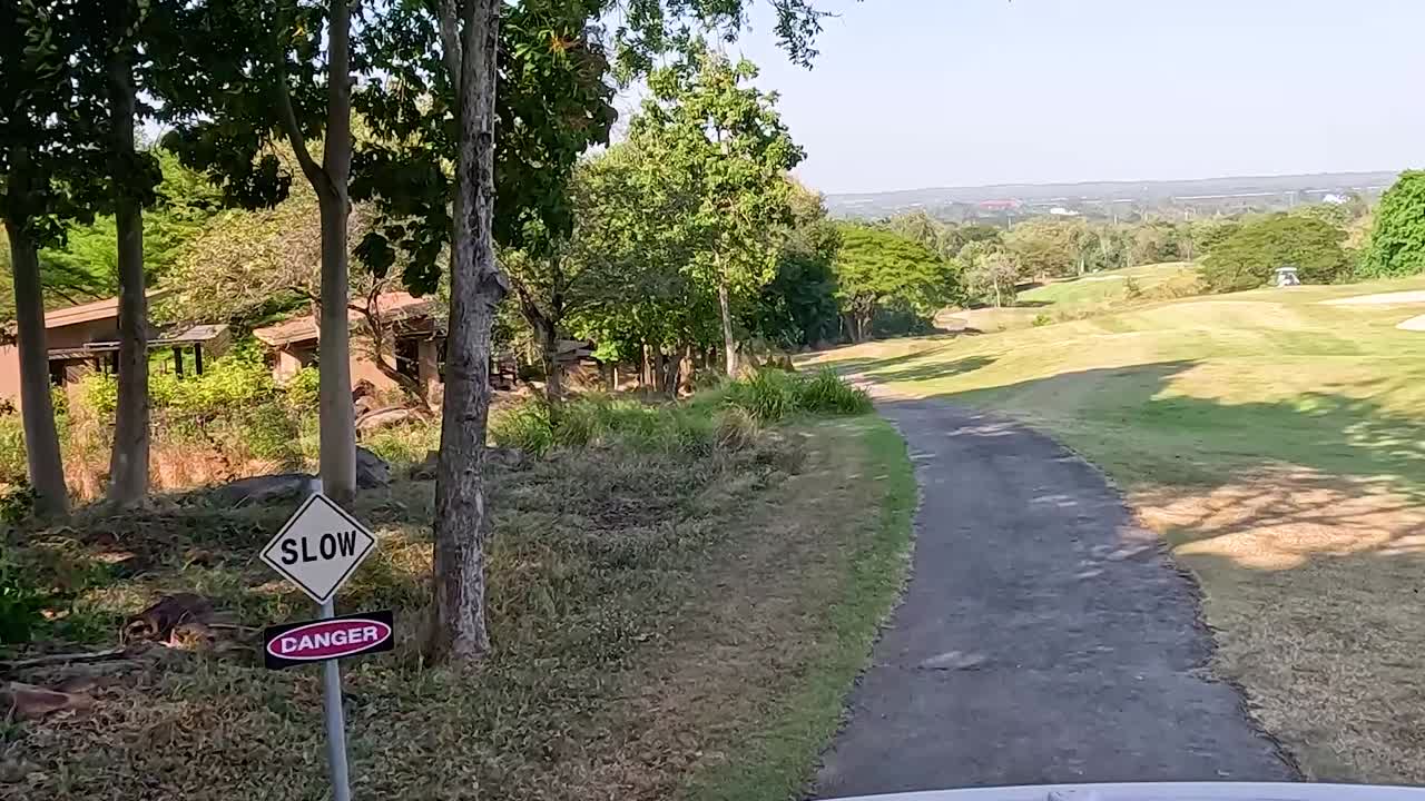 골프 카트는 울창하고 경치 좋은 풍경을 여행합니다.