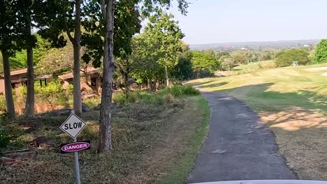 golf cart travels through lush, scenic landscape