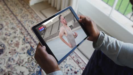 Compuesto-De-Hombre-Sentado-En-Casa,-Viendo-Un-Evento-De-Atletismo-En-Una-Tableta