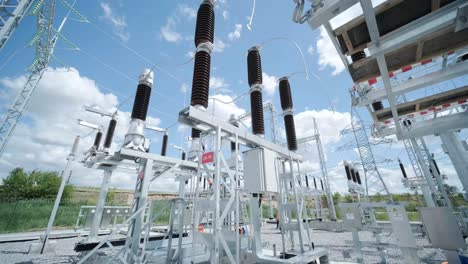 many high voltage electrical insulators in power substation against blue sky background