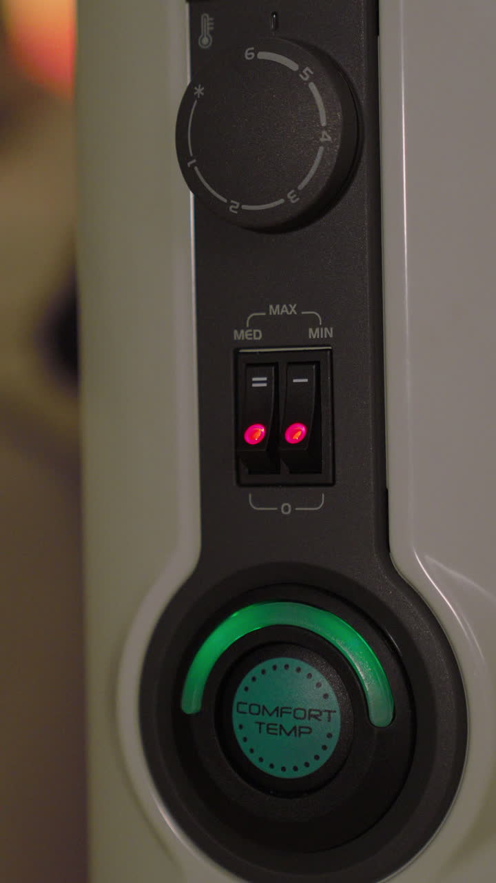 Hand activating the power switch on a modern electric heater, bringing warmth and comfort to a cold living space