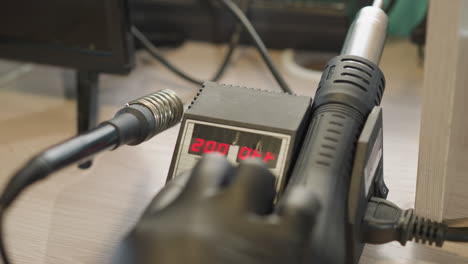 a close-up view of a technician's hand in a black glove adjusting a digital temperature control device