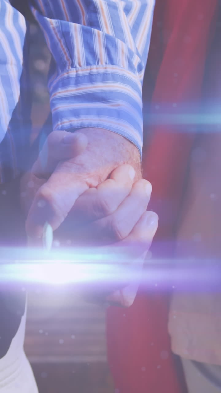 손을 잡고 공원에서  ⁇ 고 있는 노인 부부의 중간 부분을 가로질러 움직이는 빛의 애니메이션