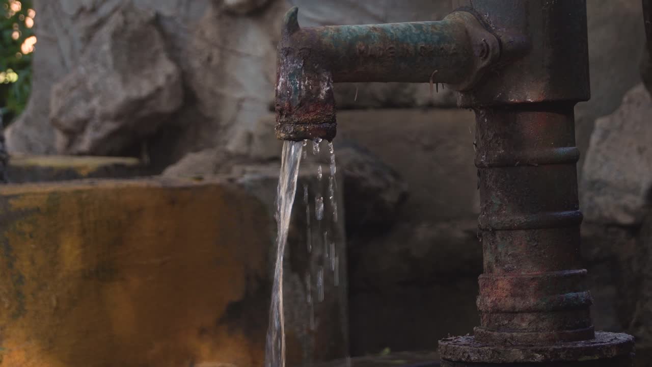Primo piano di un rubinetto e tubi trasformati in una fontana che eroga e gocciola acqua ininterrottamente