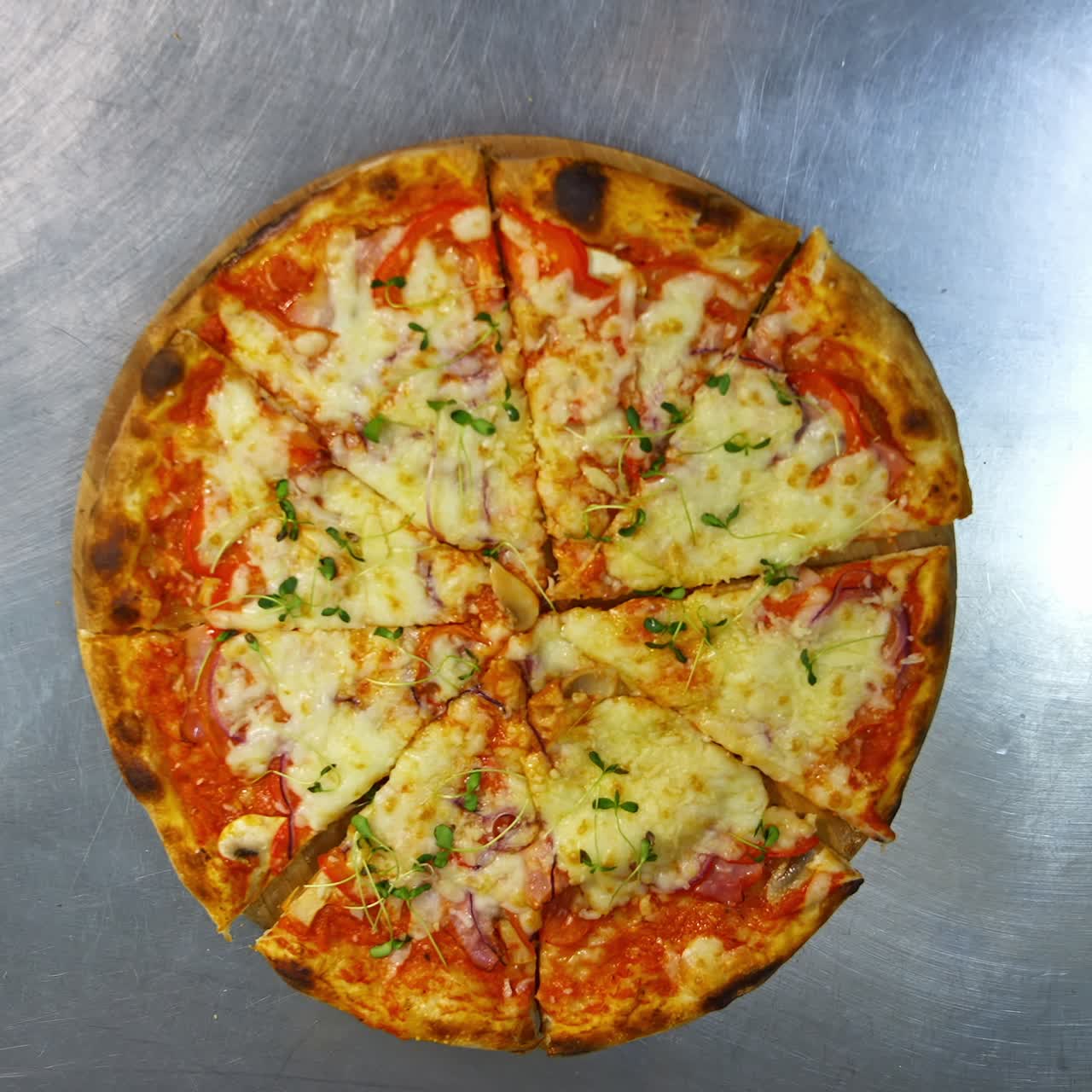 Mani che prendono porzioni di pizza. Pizza pronta sul tavolo. Persone che prendono fette di deliziosa pizza in pizzeria. Vista dall'alto.