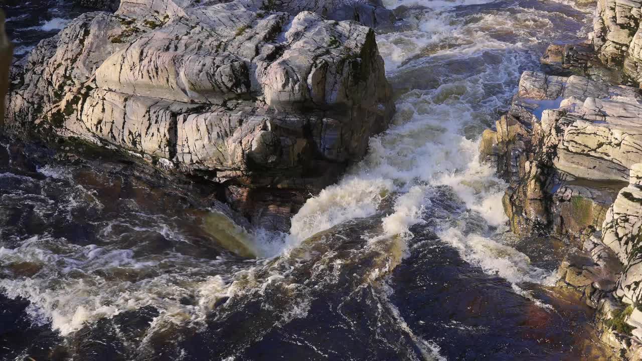 cerca de la fuerte corriente del río, el agua que fluye entre las rocas creando salpicaduras