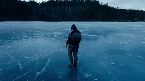 Indre-Fosen,-Trondelag-County,-Norway---A-Man-Leisurely-Strolling-Across-the-Frozen-Stretch-of-Omundvatnet---Tracking-Shot