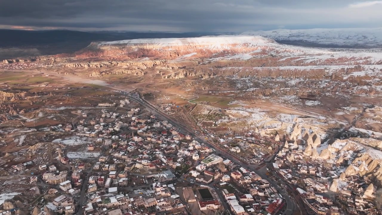Vale de Goreme e paisagem nevada da Capadócia iluminados por um nascer do sol dramático, vista panorâmica de drone.