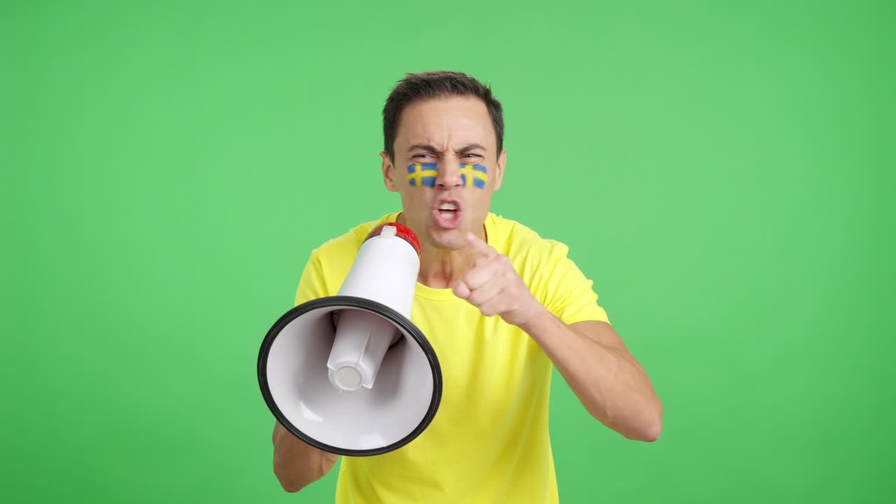 Excited man with swedish flag on face using a megaphone