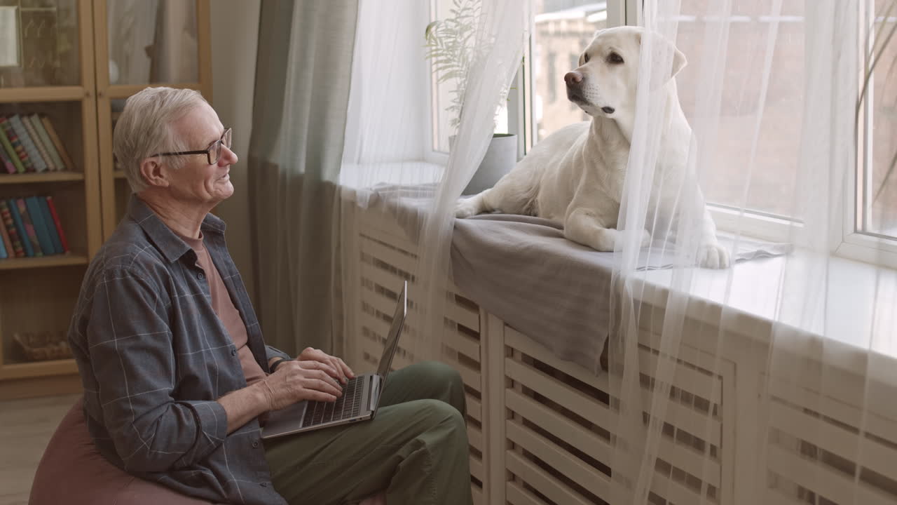 Senior Man Working on Laptop Indoors