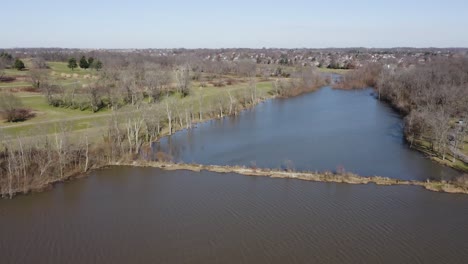 slow-trucking-pan-of-a-land-bridge-on-a-lake-in-lexington-kentucky-at-jacobson-park-on-a-bright-sunny-day-4k