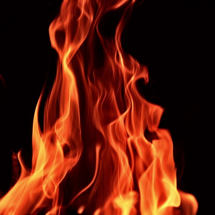 Splendide lingue di fuoco dal falò. Primo piano. Fiamma isolata su sfondo nero
