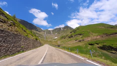 Langsame-Kamerabewegung-Mit-Einer-Straße-Im-Vordergrund-Und-Hohen-Bergen-Im-Hintergrund-Mit-Einem-Klaren-Blauen-Himmel