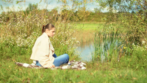 woman relaxing by a pond in autumn