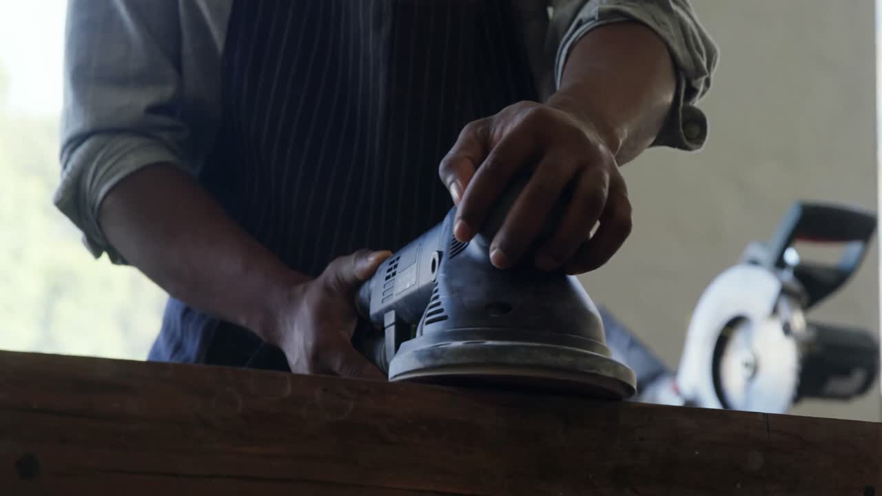 Carpenter polishing wood with machine 4k