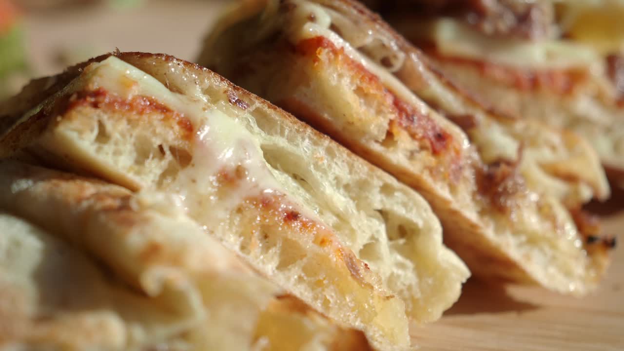 Primo Piano di Deliziose Fette di Quesadilla al Formaggio su un Tagliere di Legno