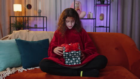 preteen girl opening gift box with light glow inside amazed satisfied with present birthday surprise