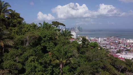 aerial climbs lush jungle on ancon hill to reveal downtown, panama city