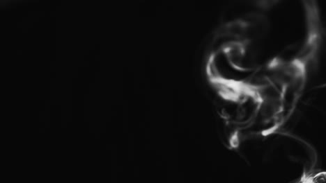 abstract black and white smoke with a black background in slow motion